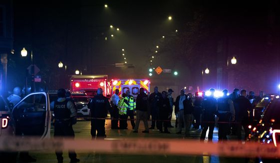Chicago police and emergency medical responders work at the scene of a mass shooting near Polk Street and California Avenue on the city&#39;s West Side on Monday, Oct. 31, 2022.  Chicago Police say several people were injured in a drive-by shooting Halloween night, including three children (E. Jason Wambsgans /Chicago Tribune via AP)