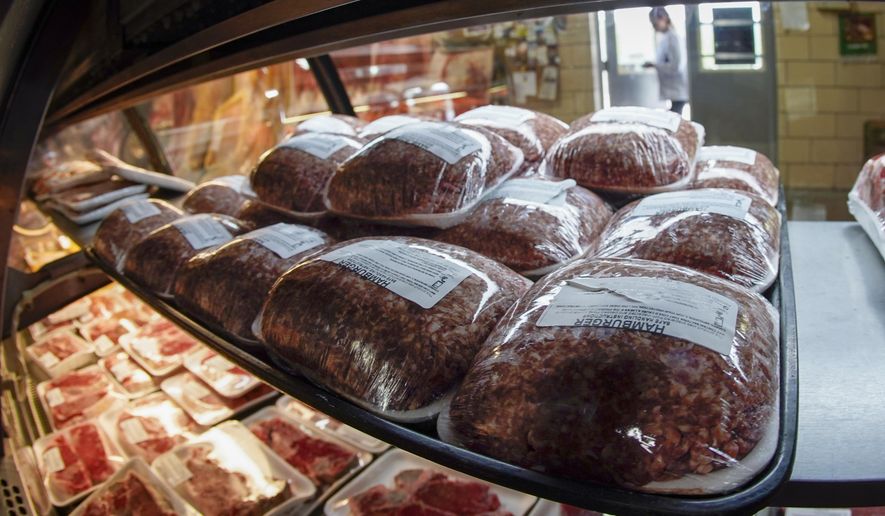 In this photo made on Thursday, June 16, 2022, fresh meat is seen through the display coolers as a woman enters the retail section at the Wight&#39;s Meat Packing facility in Fombell, Pa. On Friday the Labor Department releases the Producer Price Index for November. (AP Photo/Keith Srakocic, File) ** FILE **