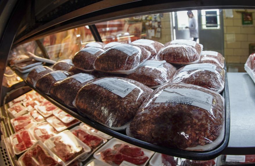 In this photo made on Thursday, June 16, 2022, fresh meat is seen through the display coolers as a woman enters the retail section at the Wight&#x27;s Meat Packing facility in Fombell, Pa. On Friday the Labor Department releases the Producer Price Index for November. (AP Photo/Keith Srakocic, File) ** FILE **