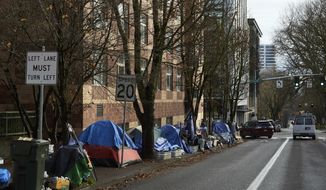 Tents line the sidewalk on SW Clay St in Portland, Ore., on Dec. 9, 2020. (AP Photo/Craig Mitchelldyer, File)