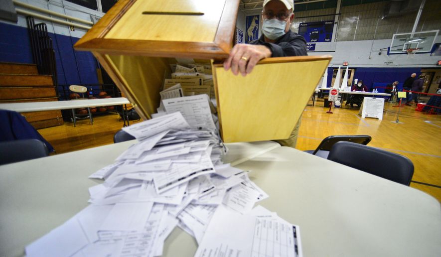 Steve Diorio, the Chair of the Hinsdale, N.H., Select Board, dumps out nearly 1900 ballots onto a table to be hand-counted at the Hinsdale Middle High School on Nov. 3, 2020 in Hinsdale, N.H. Election experts oppose hand-counting ballots because it takes longer than counting with machines, it’s less reliable and it’s a logistical nightmare for U.S. elections. (Kristopher Radder/The Brattleboro Reformer via AP, File)