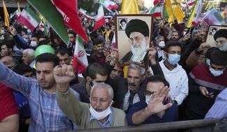 Demonstrators chant slogans as one of them holds up a poster of Iranian Supreme Leader Ayatollah Ali Khamenei during a demonstration in front of the former U.S. Embassy in Tehran, Iran, Friday, Nov. 4, 2022. Iran on Friday marked the 1979 takeover of the U.S. Embassy in Tehran as its theocracy faces nationwide protests after the death of a 22-year-old woman earlier arrested by the country&#x27;s morality police. (AP Photo/Vahid Salemi)