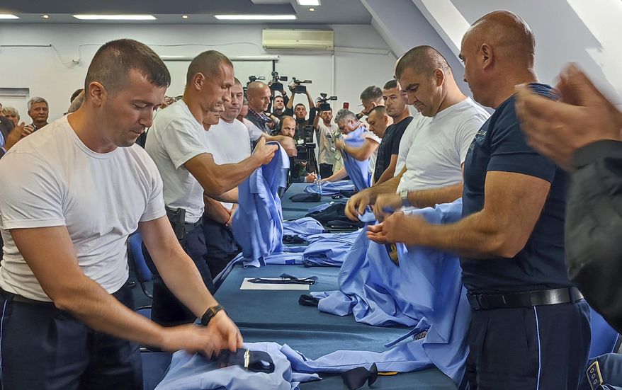 Serb police officers took off their uniforms in the town of Zvecan, Kosovo, Saturday, Nov. 5, 2022. Representatives of the ethnic Serb minority in Kosovo on Saturday resigned from their posts in protest over the dismissal of a police officer who did not follow the government&#x27;s decision on vehicle license plates. Earlier this week Pristina authorities dismissed a senior Serb police officer in northern Kosovo, where most of the ethnic Serbs live, who refused to respect the decision to change vehicle license plates in Kosovo to ones issued by Kosovo. (AP Photo/Bojan Slavkovic)