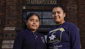 Lorena Ramirez poses with her daughter Citlalli outside St. Anthony School Thursday, Oct. 20, 2022, in Milwaukee. School choice allows taxpayer money to pay for private school tuition instead of only financing public schools. “It’s a huge difference because it’s a support in faith and in values,” said Ramirez, whose four children attend St. Anthony, walking distance from home on Milwaukee&#39;s south side. (AP Photo/Morry Gash)