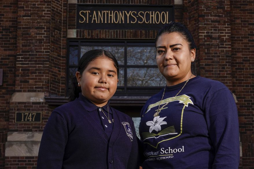 Lorena Ramirez poses with her daughter Citlalli outside St. Anthony School Thursday, Oct. 20, 2022, in Milwaukee. School choice allows taxpayer money to pay for private school tuition instead of only financing public schools. “It’s a huge difference because it’s a support in faith and in values,” said Ramirez, whose four children attend St. Anthony, walking distance from home on Milwaukee&#x27;s south side. (AP Photo/Morry Gash)