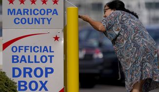 A voter drops off her ballot at a drop box, Monday, Nov. 7, 2022, in Mesa, Ariz. (AP Photo/Matt York)