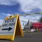 A voting sign points voters in the right direction to drop off ballots in Phoenix, Monday, Nov. 7, 2022. (AP Photo/Ross D. Franklin)