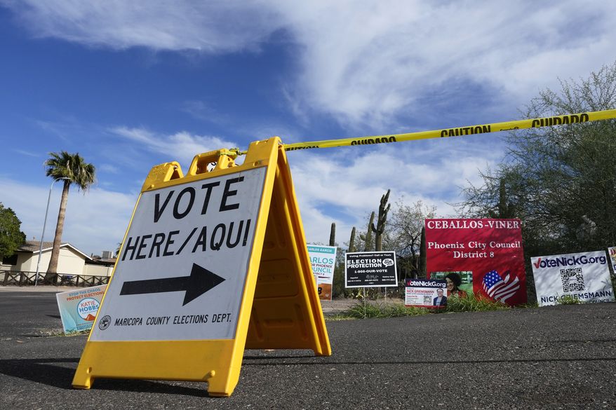 A voting sign points voters in the right direction to drop off ballots in Phoenix, Monday, Nov. 7, 2022. (AP Photo/Ross D. Franklin)