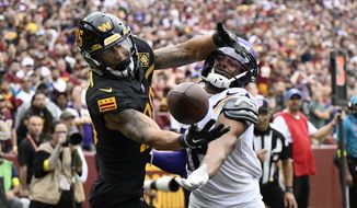 Washington Commanders cornerback Benjamin St-Juste (25) and Minnesota Vikings wide receiver Justin Jefferson (18) battle for the ball during the second half of an NFL football game, Sunday, Nov. 6, 2022, in Landover, Md. (AP Photo/Nick Wass)
