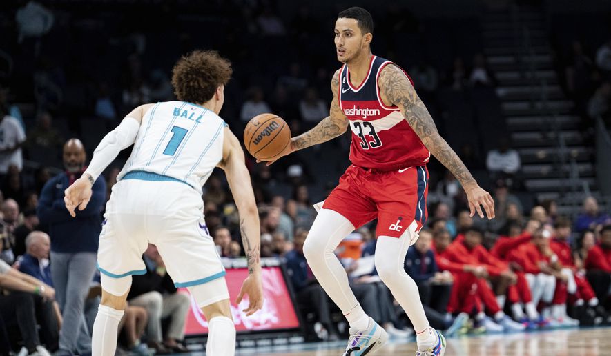 Washington Wizards forward Kyle Kuzma (33) brings the ball up court while guarded by Charlotte Hornets guard LaMelo Ball (1) in the second half of an NBA preseason basketball game in Charlotte, N.C., Monday, Oct. 10, 2022. (AP Photo/Jacob Kupferman)