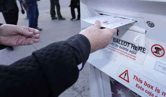 A voter places a ballot in a drop box outside the Denver Elections Division headquarters easrly Tuesday, Nov. 8, 2022, in downtown Denver. (AP Photo/David Zalubowski)