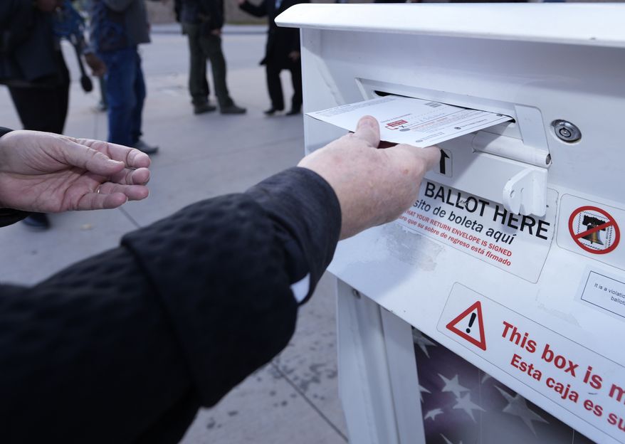 A voter places a ballot in a drop box outside the Denver Elections Division headquarters easrly Tuesday, Nov. 8, 2022, in downtown Denver. (AP Photo/David Zalubowski)