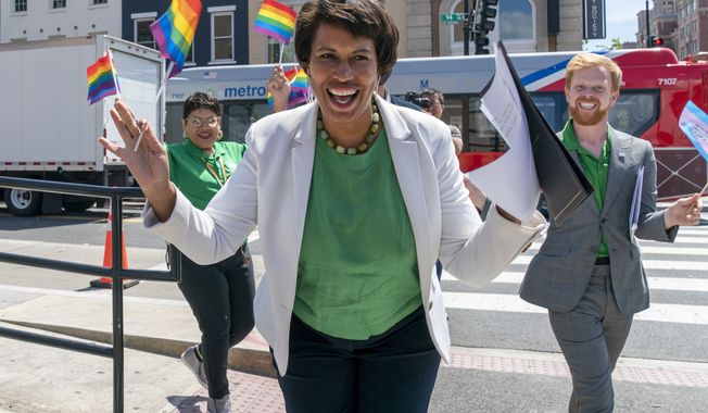 FILE - District of Columbia Mayor Muriel Bowser, center, arrives for a news conference ahead of DC Pride events, June 10, 2022, in Washington. At right is Japer Bowles, director of the Mayor&#x27;s Office of Lesbian, Gay, Bisexual, Transgender and Questioning Affairs. (AP Photo/Jacquelyn Martin)