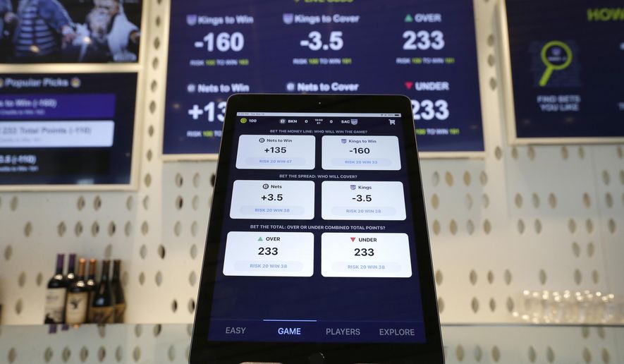 An iPad displays the types of free bets that could be placed at the Golden 1 Center&#39;s Skyloft Predictive Gaming Lounge in Sacramento, Calif., March 19, 2019. (AP Photo/Rich Pedroncelli, File)
