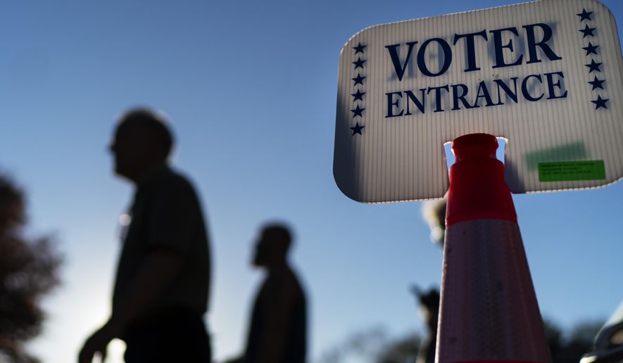 Voters pass a sign outside a polling site in Warwick, R.I., Monday, Nov. 7, 2022, after casting their ballots on the last day of early voting before the midterm election. (AP Photo/David Goldman)