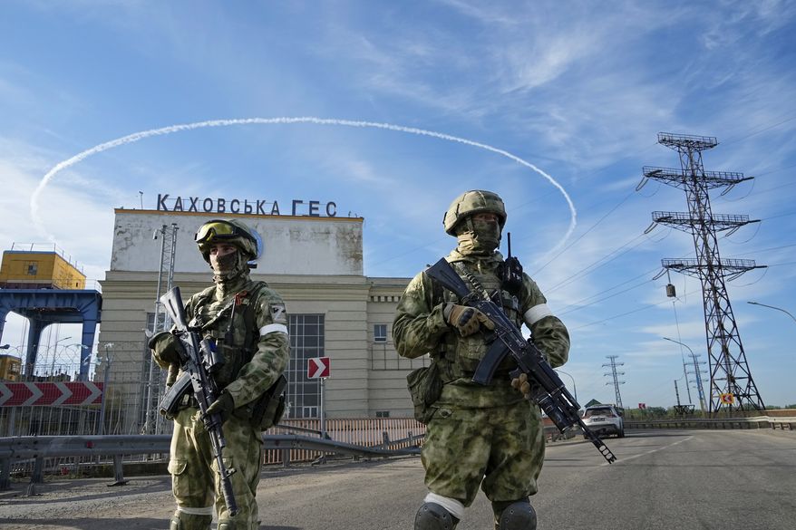 Russian troops guard an entrance of the Kakhovka Hydroelectric Station, a run-of-river power plant on the Dnieper River in the Kherson region, south Ukraine, Friday, May 20, 2022. Russia’s military has announced that it’s withdrawing from Ukraine's southern city of Kherson and nearby areas. That would be another in a series of humiliating setbacks for Moscow’s forces in the 8-month-old war. (AP Photo, File) **FILE**