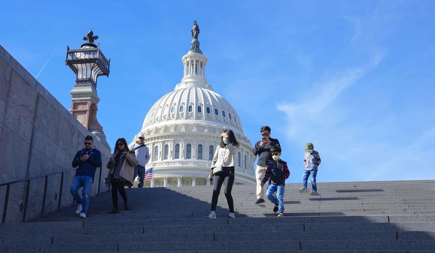 With the U.S Capitol in the background, people walk down steps on Election Day in Washington, Tuesday, Nov. 8, 2022. (AP Photo/Mariam Zuhaib)