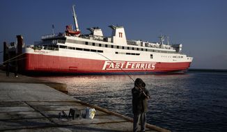 A man fishes as a ferry is docked during a 24-hour strike at the port of Rafina, east of Athens, Greece, Wednesday, Nov. 9, 2022. A 24-hour general strike called by Greece&#39;s private and public sector unions is set to shut down most services around the country Wednesday. (AP Photo/Thanassis Stavrakis)