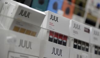 Juul products are displayed at a smoke shop in New York, on Dec. 20, 2018. Embattled vaping company Juul Labs announced layoffs Thursday, Nov. 10, 2022, as the company tries to weather growing setbacks to its electronic cigarette business, including lawsuits, government bans and increasing competition. (AP Photo/Seth Wenig, File)