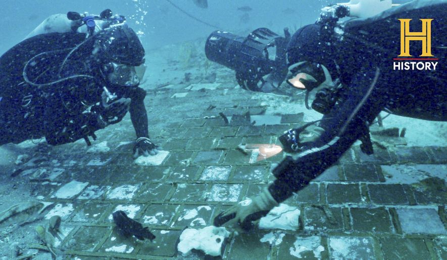 In this photo provided by the HISTORY® Channel, underwater explorer and marine biologist Mike Barnette and wreck diver Jimmy Gadomski explore a 20-foot segment of the 1986 Space Shuttle Challenger that the team discovered in the waters off the coast of Florida during the filming of The HISTORY® Channel’s new series, “The Bermuda Triangle: Into Cursed Waters,” premiering Tuesday, Nov. 22, 2022. (The HISTORY® Channel via AP)