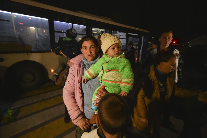 Evacuees from Kherson walk from a bus upon their arrival to Dzhankoi, Crimea, Thursday, Nov. 10, 2022. Russian Defense Minister Sergei Shoigu ordered a troop withdrawal from Kherson and nearby areas on Wednesday after his top general in Ukraine reported that a loss of supply routes during Ukraine's southern counteroffensive made a defense "futile." (AP Photo)