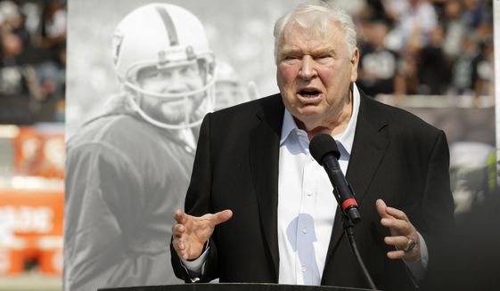 Former Oakland Raiders head coach John Madden speaks about former quarterback Ken Stabler, pictured at rear, during a ceremony honoring Stabler at halftime of an NFL football game between the Raiders and the Cincinnati Bengals in Oakland, Calif., on Sept. 13, 2015. The NFL is making that a lasting tribute by honoring the late broadcaster by launching “The Annual John Madden Thanksgiving Celebration” to begin on the first Thanksgiving following his death last December. The league plans for the Thanksgiving tribute to Madden to be an annual event starting Nov. 24 when there will be special segments on all three broadcasts by CBS, Fox and NBC dedicated to Madden.(AP Photo/Ben Margot, File)