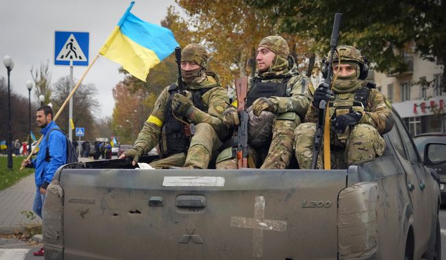 Ukrainian soldiers sit in a pickup in central Kherson, Ukraine, Sunday, Nov. 13, 2022. The Russian retreat from Kherson marked a triumphant milestone in Ukraine&#x27;s pushback against Moscow&#x27;s invasion almost nine months ago. (AP Photo/Efrem Lukatsky)