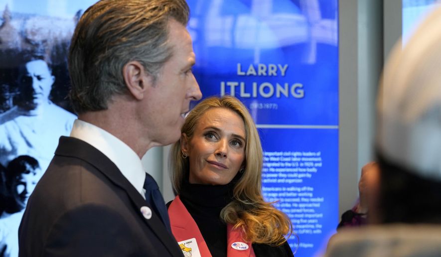 California Gov. Gavin Newsom talks to reporters after he and his wife, first partner Jennifer Siebel Newsom, right, voted in Sacramento, Calif., Tuesday, Nov. 8, 2022. Newsom is running for reelection against Republican state Sen. Brian Dahle. (AP Photo/Rich Pedroncelli)