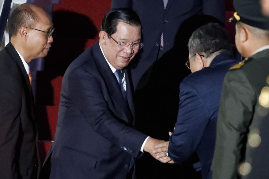 Cambodia&#x27;s Prime Minister Hun Sen, center,  arrives at Ngurah Rai International Airport ahead of the G20 Summit in Bali, Indonesia on Nov. 14, 2022. Hun Sen tests positive for COVID-19 at G-20, days after hosting world leaders at summit in Phnom Penh. (Ajeng Dinar Ulfiana/Pool Photo via AP)