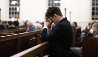 A person prays at a service at St. Paul&#39;s Memorial Church in response to the shootings that happened on the University of Virginia campus the night before in Charlottesville, Va., Monday, Nov. 14, 2022. (Mike Kropf/The Daily Progress via AP)