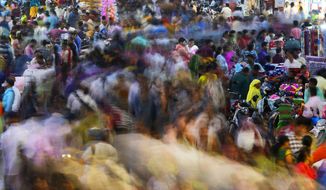 People move through a market in Mumbai, India, Saturday, Nov. 12, 2022. The world&#39;s population is projected to hit an estimated 8 billion people on Tuesday, Nov. 15, according to a United Nations projection. (AP Photo/Rajanish Kakade)