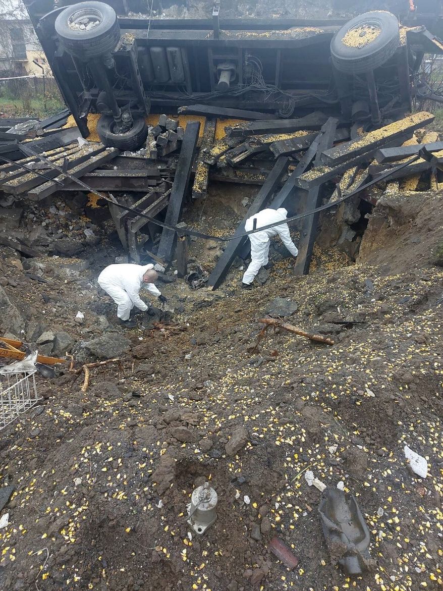 In this image made available by Polish Police, experts look through the site where a Russian-made missile hit, killing two men, in Przewodowo, eastern Poland, on Wednesday Nov. 16, 2022. Polish and NATO leaders say it was most probably an accident and not an intentional attack on Poland. (Polish Police via AP)