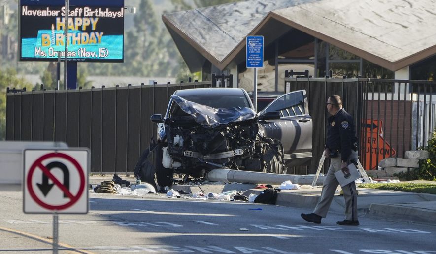 An investigator walks past a mangled SUV that struck Los Angeles County sheriff&#39;s recruits in Whittier, Calif., Wednesday, Nov. 16, 2022. The vehicle struck several Los Angeles County sheriff&#39;s recruits on a training run around dawn Wednesday, some were critically injured, authorities said. (AP Photo/Jae C. Hong)