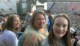 This photo shows Natasha Mitchner, center, at a Taylor Swift concert in Columbus, Ohio, on July 7, 2018, with her now 17-year-old daughter, Melisse Bretz, left, and her now 20-year-old daughter, Amea Bretz. Mitchner scored tickets to a Taylor Swift concert during her tour next year after several hours in the Ticketmaster queue. (Natasha Mitchner via AP)