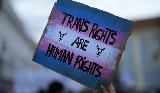 A demonstrator holds up a sign during a march to mark International Transgender Day of Visibility in Lisbon, March 31, 2022. At least 32 transgender and gender-nonconforming people have been killed in the United States in 2022, the Human Rights Campaign announced Wednesday, Nov. 16, in its annual report ahead of Transgender Day of Remembrance on Sunday, Nov. 20. (AP Photo/Armando Franca, File)