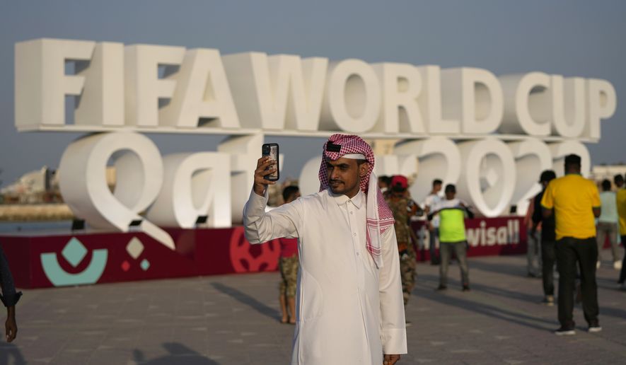 A man takes a selfie with a sign reading in English&amp;quot; Fifa World Cup, Qatar 2022&amp;quot; at the corniche in Doha, Qatar, Friday, Nov. 11, 2022. With no soccer tradition but billions in oil money, Qatar is the latest Persian Gulf nation using sports to try to burnish its image on the global stage. The host of the 2022 World Cup is smaller than Connecticut and has a population of fewer than 3 million. (AP Photo/Hassan Ammar, File) **FILE**