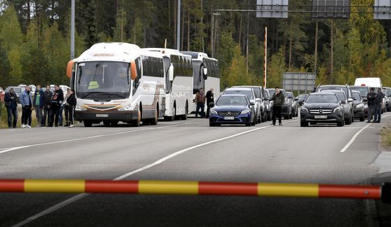 People traveling from Russia in cars and coaches queue to cross the border to Finland at the Vaalimaa border check point in Virolahti, Finland, Sunday, Sept. 25, 2022. The long border between Finland and Russia runs through thick forests and is marked only by wooden posts with low fences meant to stop stray cattle. Soon, a stronger, higher fence will be erected on parts of the frontier. (Jussi Nukari/Lehtikuva via AP, File)
