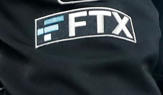 The FTX logo appears on home plate umpire Jansen Visconti&#39;s jacket at a baseball game with the Minnesota Twins on Tuesday, Sept. 27, 2022, in Minneapolis. (AP Photo/Bruce Kluckhohn, File)
