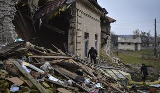A Ukrainian sapper inspects a destroyed building during the demining of a residential area in Novoselivka, Donetsk region, Ukraine, Wednesday, Nov. 16, 2022. (AP Photo/Andriy Andriyenko)