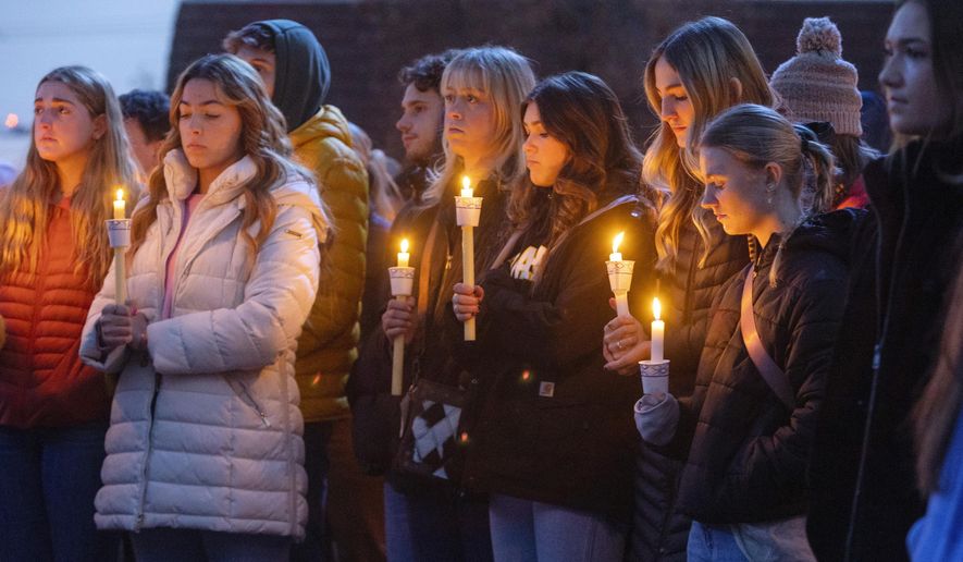 Boise State University students, along with people who knew the four University of Idaho students who were found killed in Moscow, Idaho, days earlier, pay their respects at a vigil held in front of a statue on the Boise State campus, Thursday, Nov. 17, 2022, in Boise, Idaho. Autopsies performed on the four students who were found dead inside a rental house near campus showed that all four were stabbed to death, the Latah County coroner said. (Sarah A. Miller/Idaho Statesman via AP)