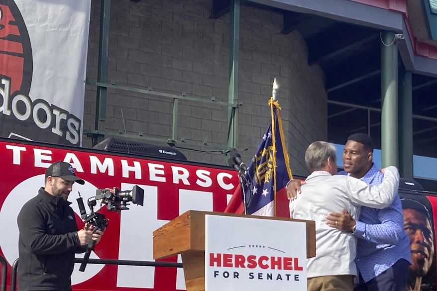 Georgia Gov. Brian Kemp campaigns alongside Senate candidate Herschel Walker on Saturday, Nov. 19, 2022 in Smyrna, Ga.   (AP Photo/Bill Barrow)