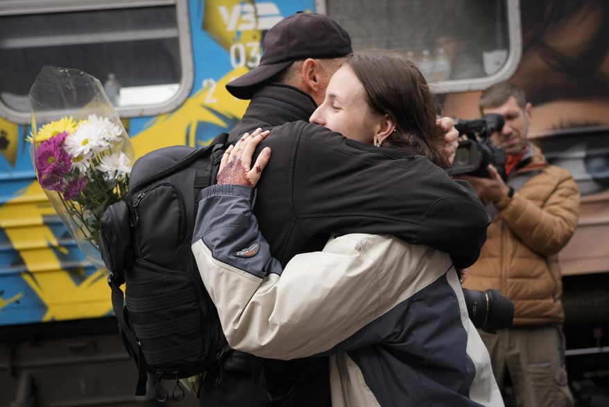 People hug upon the arrival of the first train from the capital Kyiv, after the Russian troops withdrew from the city of Kherson, Ukraine, Saturday, Nov. 19, 2022. (AP Photo/Sam Mednick)