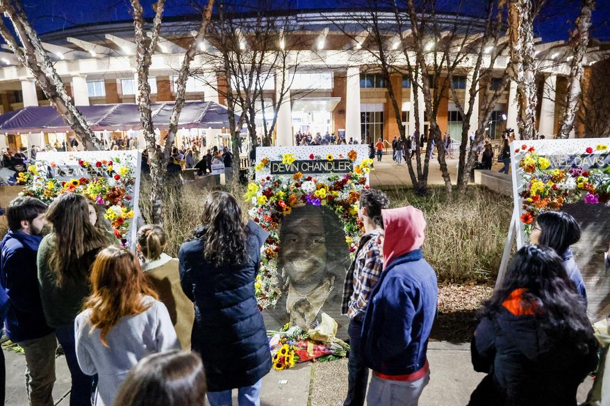 Community members attend a memorial service on Saturday, Nov. 19, 2022, at John Paul Jones Arena on the campus of the University of Virginia in Charlottesville, Va., for three slain University of Virginia football players, who were fatally shot as they returned from a field trip last weekend.  (Shaban Athuman/Richmond Times-Dispatch via AP)