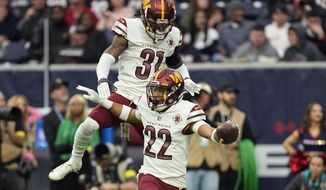 Washington Commanders safety Darrick Forrest (22) celebrates his interceptions against the Houston Texans with teammate Kamren Curl (31) during the second half of an NFL football game Sunday, Nov. 20, 2022, in Houston. (AP Photo/David J. Phillip)