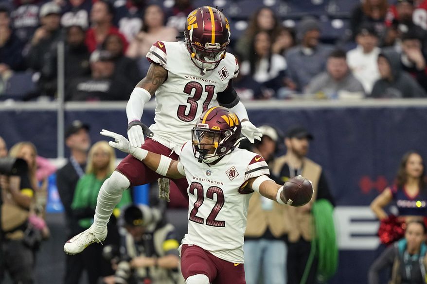 Washington Commanders safety Darrick Forrest (22) celebrates his interceptions against the Houston Texans with teammate Kamren Curl (31) during the second half of an NFL football game Sunday, Nov. 20, 2022, in Houston. (AP Photo/David J. Phillip)