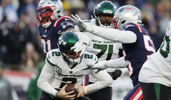 New York Jets quarterback Zach Wilson (2) is sacked by New England Patriots defensive end Deatrich Wise Jr. (91) and linebacker Josh Uche (55) during the second half of an NFL football game, Sunday, Nov. 20, 2022, in Foxborough, Mass. (AP Photo/Michael Dwyer)