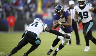 Baltimore Ravens running back Justice Hill (43) tries to get by Carolina Panthers cornerback Jaycee Horn (8) in the second half of an NFL football game Sunday, Nov. 20, 2022, in Baltimore. (AP Photo/Nick Wass)