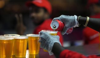 Staff member pours a beer at a fan zone ahead of the FIFA World Cup, in Doha, Qatar Saturday, Nov. 19, 2022. The last-minute decision to ban the sale of beer at World Cup stadiums in Qatar is the latest example of some the tensions that have played out ahead of the tournament. Qatari officials have for long said they were eager to welcome everybody but that visitors should also respect their culture and traditions. (AP Photo/Petr Josek) ** FILE **