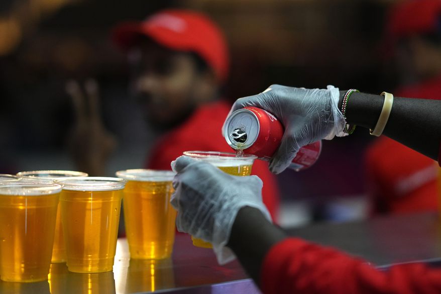 Staff member pours a beer at a fan zone ahead of the FIFA World Cup, in Doha, Qatar Saturday, Nov. 19, 2022. The last-minute decision to ban the sale of beer at World Cup stadiums in Qatar is the latest example of some the tensions that have played out ahead of the tournament. Qatari officials have for long said they were eager to welcome everybody but that visitors should also respect their culture and traditions. (AP Photo/Petr Josek) ** FILE **
