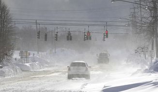 Cars drive through blowing, drifting snow on McKinley Parkway in Hamburg in Erie County, N.Y., Sunday, Nov. 20, 2022. (Mark Mulville/The Buffalo News via AP)